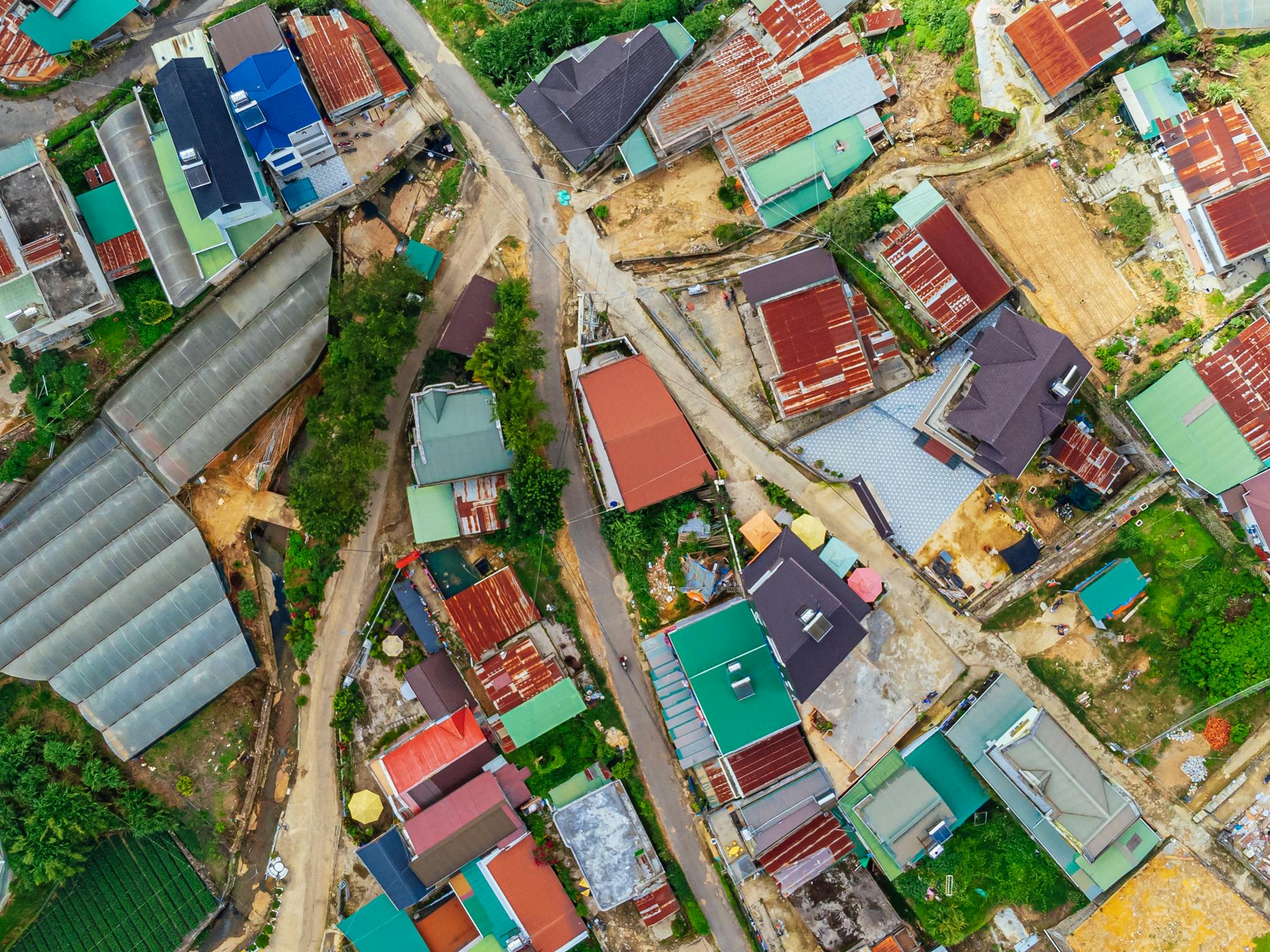 A vibrant aerial view of urban houses with mixed styles and colors, showcasing a lively neighborhood.