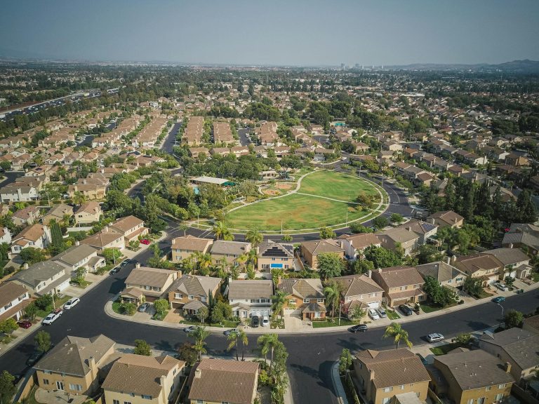 Drone aerial view of a spacious suburban neighborhood with a central park area.